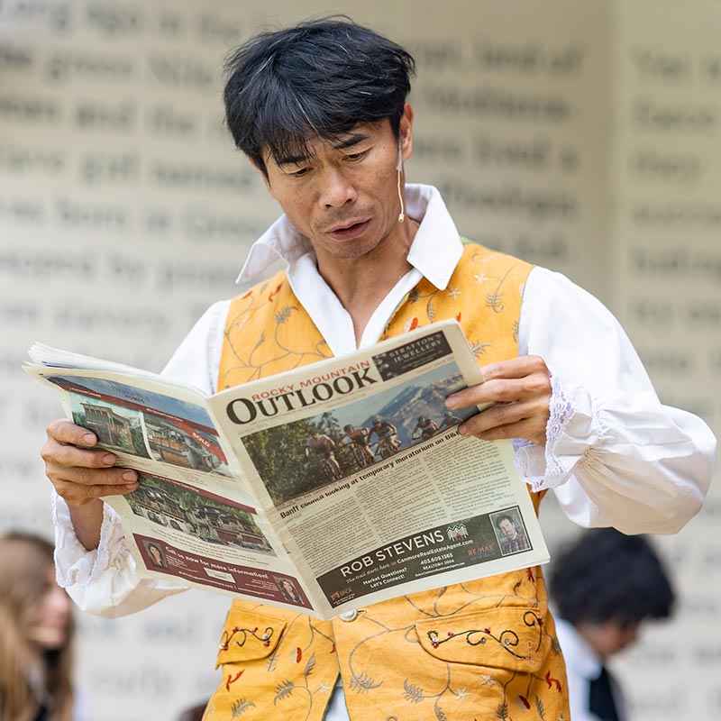 Actor on stage reading the newspaper